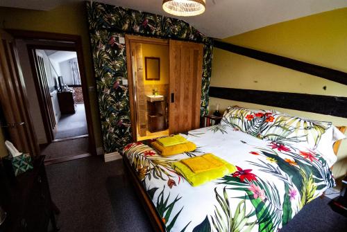 a bedroom with a large bed with a floral bedspread at High Barn in Thursley