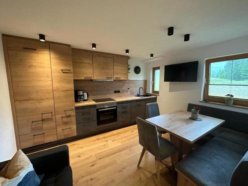 eine Küche mit Holzschränken und einem Esstisch aus Holz in der Unterkunft Bauernhaus Durrahof in Steinberg am Rofan