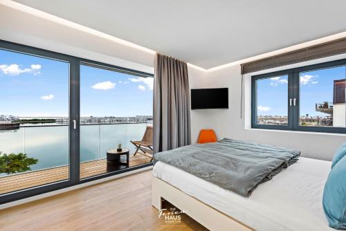 a bedroom with a bed and large windows at ROOFTOP Garden ACHT in Olpenitz