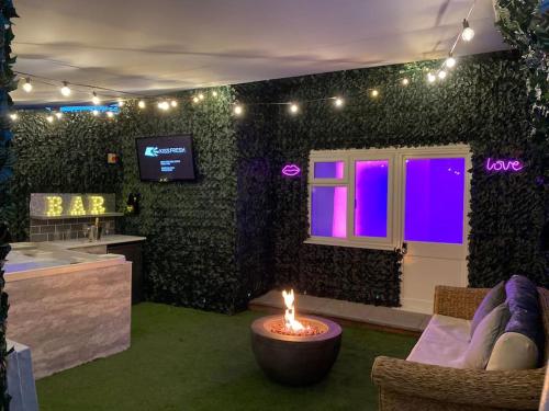 um quarto com uma sala de estar com uma vela no meio em Luxury Urban Hideaway with private hot tub & Pole em Croydon