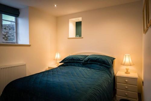 a bedroom with a bed with two lamps and a mirror at Cart House - Stunning Cottage - Axbridge in Axbridge