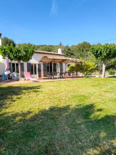 une maison avec une pelouse devant dans l'établissement Le bastidon de Sanary- piscine et jardin paysagé., à Sanary-sur-Mer