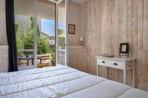 - une chambre avec un lit et une vue sur une terrasse dans l'établissement Rez de jardin à 400m de la Plage pour 4, à Pornic