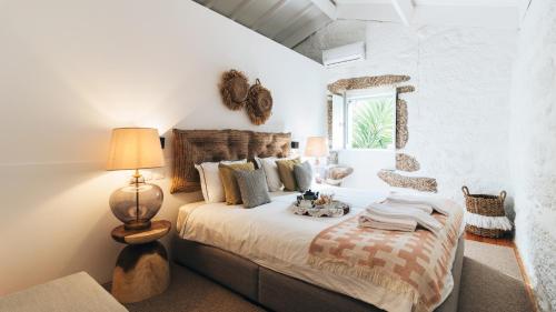 a bedroom with a bed and a lamp and a window at Casa da Cascata in Geres