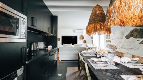 a kitchen with a dining table and a living room at Casa da Cascata in Geres
