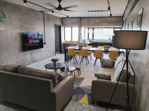 a living room with couches and a dining room at Golden Hill Resort Genting Highland in Genting Highlands