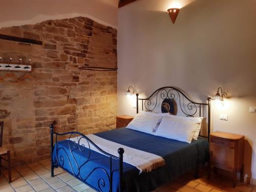 1 dormitorio con 1 cama en una habitación con una pared de piedra en La Stradella Appartamenti Vacanze, en Castiglione Messer Raimondo