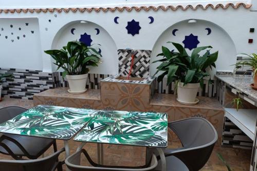 Casa preciosa con vistas في غرناطة: فناء مع طاولة وكراسي والنباتات
