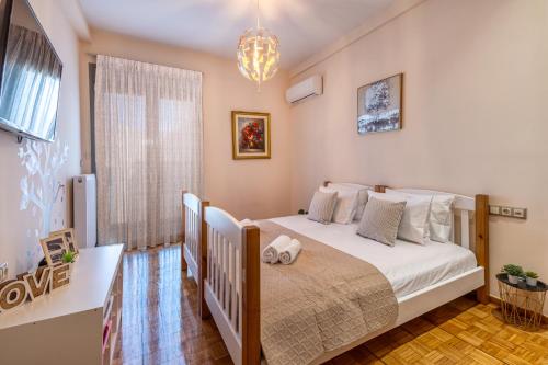 um quarto com uma cama branca e uma janela em Androgeōs seaview apartment em Rethymno Town