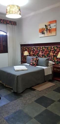 a bedroom with a large bed with pillows on it at hotel fazenda encanto in Guararema