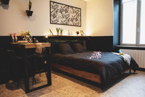 昂熱的住宿－LOVE ROOM, La Douce Angevine，一间卧室配有一张床、一张桌子、一张桌子和一张四柱床。