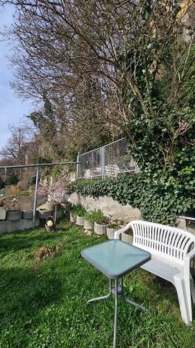 a white bench and a table in the grass at Schwabenstuben Einzelzimmer in Meersburg