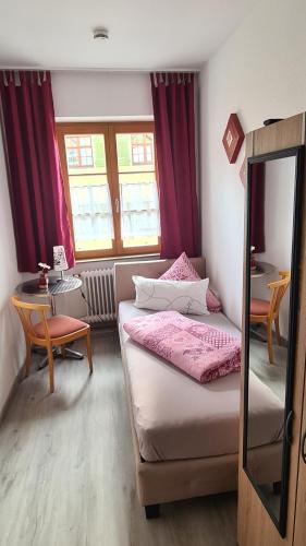 sypialnia z 2 łóżkami, stołem i lustrem w obiekcie Schwabenstuben Einzelzimmer w mieście Meersburg