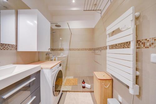 Elle comprend une petite salle de bains pourvue d'un lave-linge et d'un sèche-linge. dans l'établissement Le Précieux - Appt Place de la Victoire, à Bordeaux