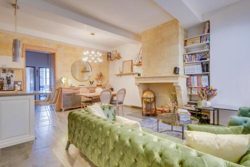 - un salon avec un canapé vert et une cheminée dans l'établissement Le Précieux - Appt Place de la Victoire, à Bordeaux
