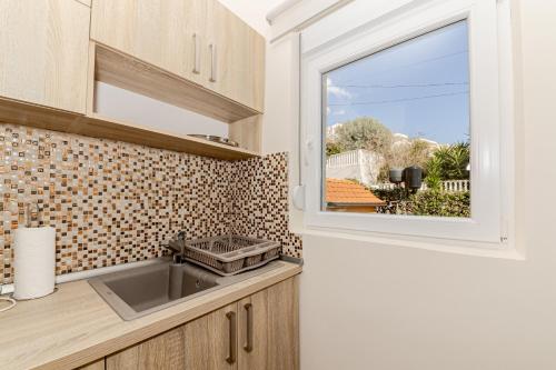 eine Küche mit einem Waschbecken und einem Fenster in der Unterkunft Apartments Katarina in Ðenovići