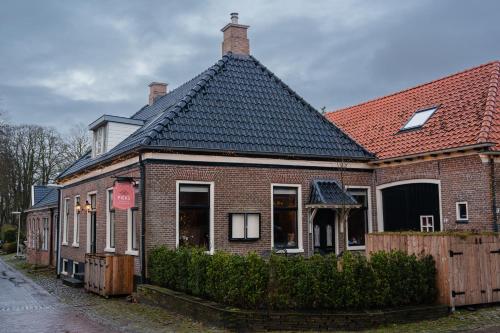 ein rotes Backsteinhaus mit schwarzem Dach in der Unterkunft Pieks Noordlaren in Noordlaren