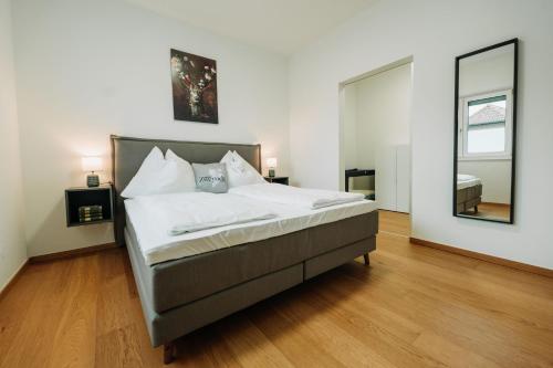 a bedroom with a bed and a large mirror at Weingut Zweytick Lodge Vinoment in Ehrenhausen