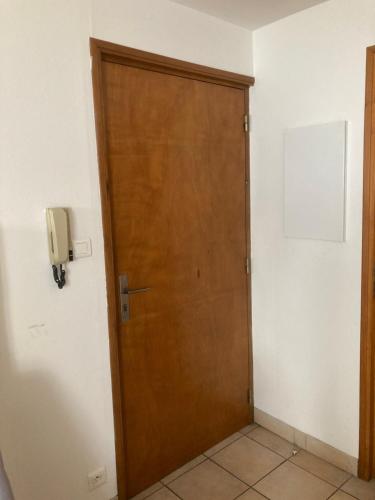 uma porta de madeira num quarto com um telefone na parede em Au bon lieu em Bouloc