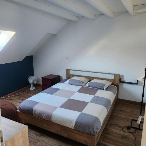 a bedroom with a large bed with a checkered blanket at Magnifique logement spa in Pau