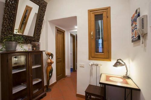 een hal met een tafel, een spiegel en een lamp bij Faenza-3 bedrooms apartment in Florence's center in Florence