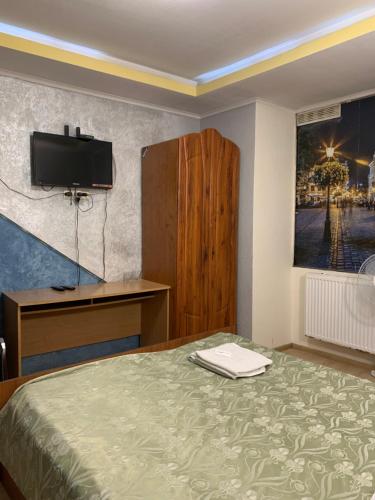 a bedroom with a bed and a desk and a television at Апартаменти готельного типу in Lviv