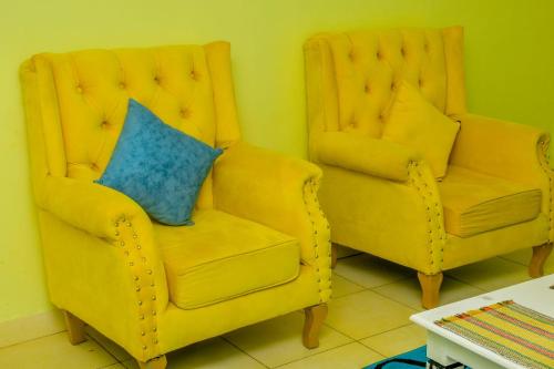 zwei gelbe Stühle nebeneinander sitzen in der Unterkunft The O,S Homestay in Chuka