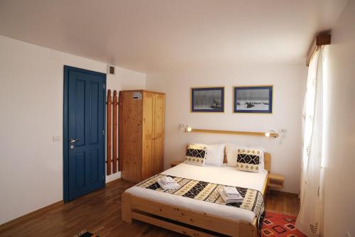 a bedroom with a bed and a blue door at PRIVET in Jurilovca