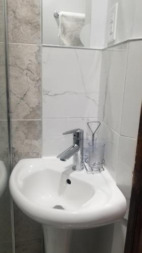 a white sink in a bathroom with a mirror at Tina's gem in Ottawa