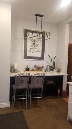 a kitchen with a counter with two chairs and a table at Tina's gem in Ottawa
