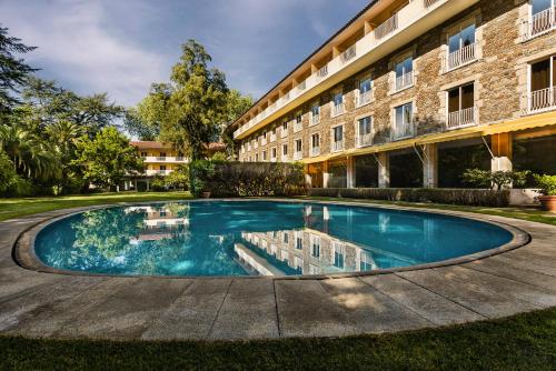 a swimming pool in front of a building at Hotel Grao Vasco in Viseu