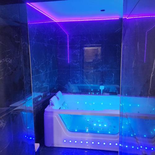 a bathroom with a tub with a purple lighting at Loveroom Pau in Pau