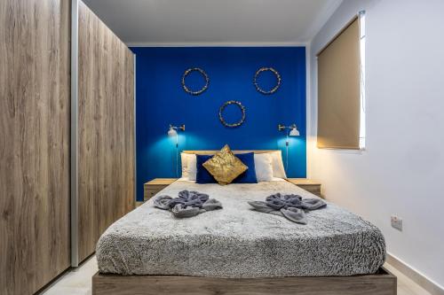 - une chambre avec un grand lit aux murs bleus dans l'établissement Ta Cetta Apartment 5 min walk from St Julians, à San Ġwann