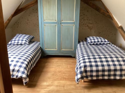 2 Betten in einem Zimmer mit blauer Tür in der Unterkunft Gîte de la vallée in Volnay