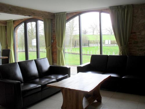 a living room with a couch and a coffee table at Swallows Swoop at Tove Valley Cottages in Towcester
