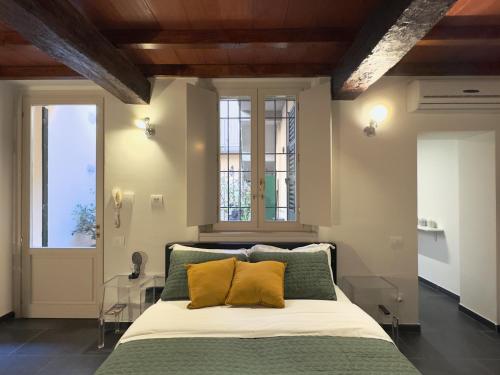 una camera da letto con un letto con cuscini verdi e gialli di Violino green a Cremona
