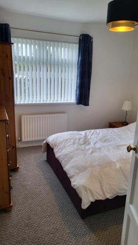 a bedroom with a bed and a large window at Gortree at Castlerock in Castlerock