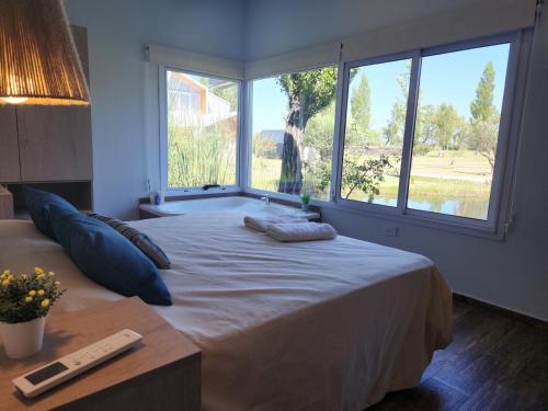 a bedroom with a large bed with a large window at Finca La Escondida San Rafael in San Rafael