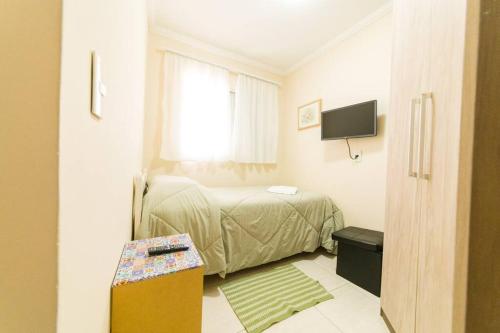 een kleine slaapkamer met een bed en een raam bij Local aconchegante e tranquilo. in Sao Paulo