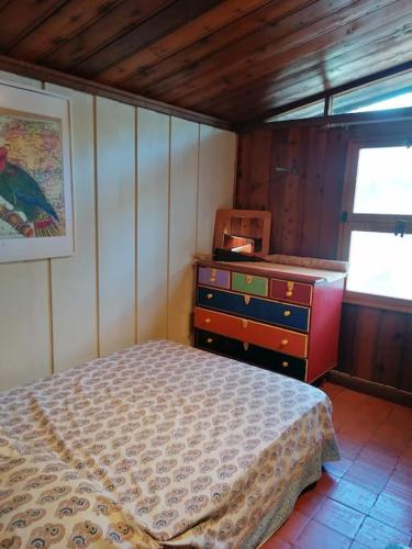a bedroom with a bed and a dresser and a window at Casa da Lagoa - House by the Lagoon with Direct Access to the Beach in Sesimbra