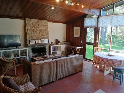 Casa da Lagoa في سيسيمبرا: غرفة معيشة مع أريكة ومدفأة
