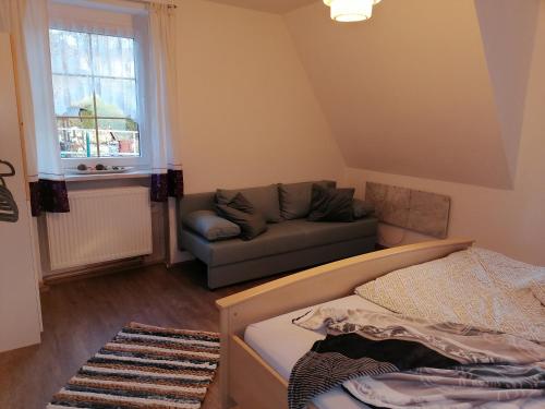 a living room with a bed and a couch at Zur Waldhufe in Königswalde