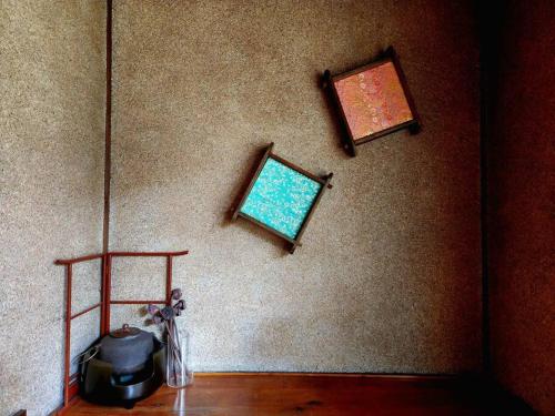 a room with two pictures on the wall at Nogataの商店街の一角にあるちいさな隠れ家　忘覚庵 in Nōgata