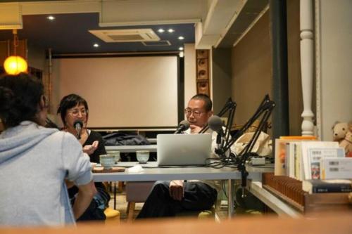 a group of people sitting at a table with a laptop at Nogataの商店街の一角にあるちいさな隠れ家　忘覚庵 in Nōgata