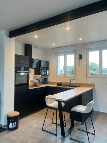 - une cuisine avec une table et deux chaises dans l'établissement Gîte Kernico, à Plounévez-Lochrist