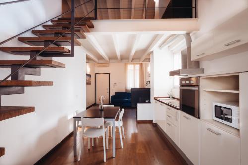 a kitchen and dining room with a spiral staircase at Charming Milan Apartments Brera - Madonnina in Milan