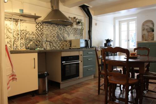 a kitchen with a table and a stove top oven at Maison de village centre Quinson in Quinson