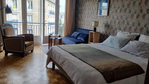 a bedroom with a bed and a chair and a window at Studio Roy Gradlon Quimper in Quimper