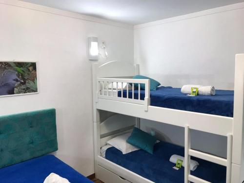 a bedroom with two bunk beds with blue sheets at Hospedagem Vida e Natureza in Gramado