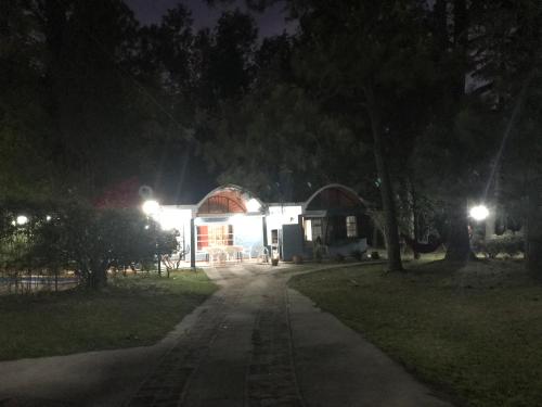 een huis 's nachts met een weg die naar het bij Quinta ubuntu tu lugar para el descanso in La Reja